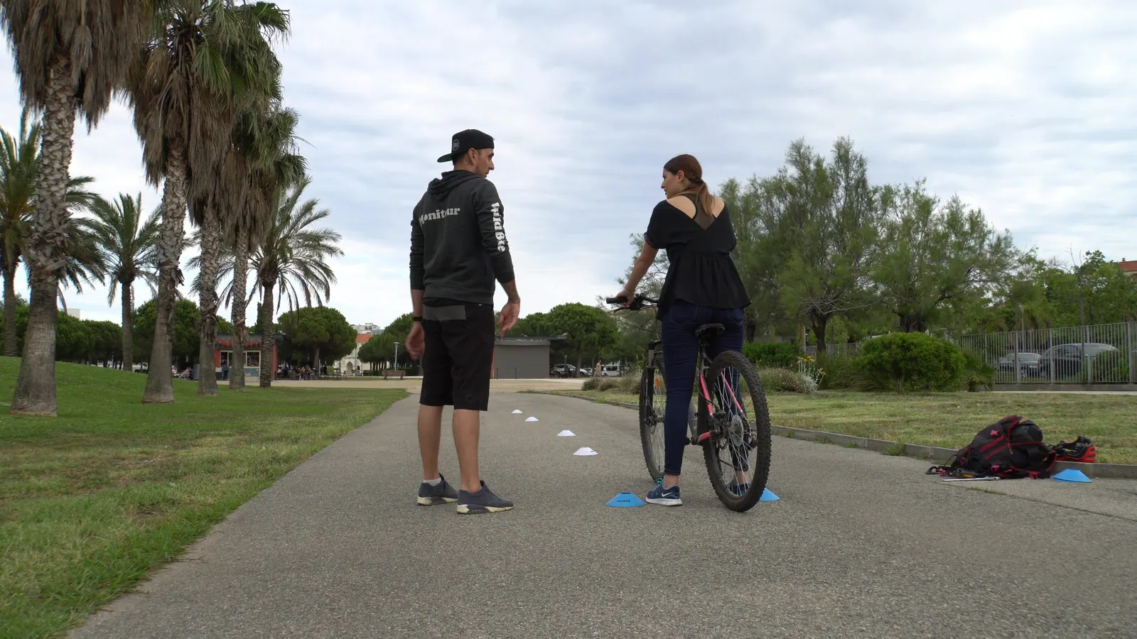 Une adulte accompagnée par un moniteur Wild Bike pendant une séance de vélo-école